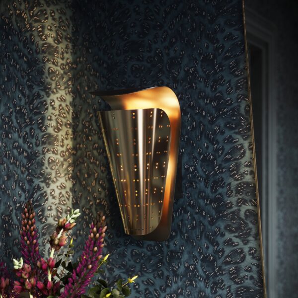 Mirage perforated wall sconce in unlacquered brass on a dark blue patterned wall