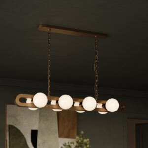 Rio linear suspension light in unlacquered brass in a dark green dining room