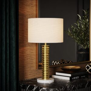 Roma fluted column table lamp in unlacquered brass on a black marble sideboard, close-up