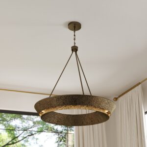 Manhattan hammered ring chandelier in unlacquered brass hanging in a light-filled room