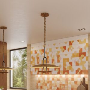 Trousdale disc pendant in unlacquered brass over a kitchen island with orange tile
