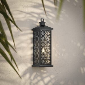 Marrakesh arabesque outdoor wall light in dark bronze on a stucco wall with palm shadows